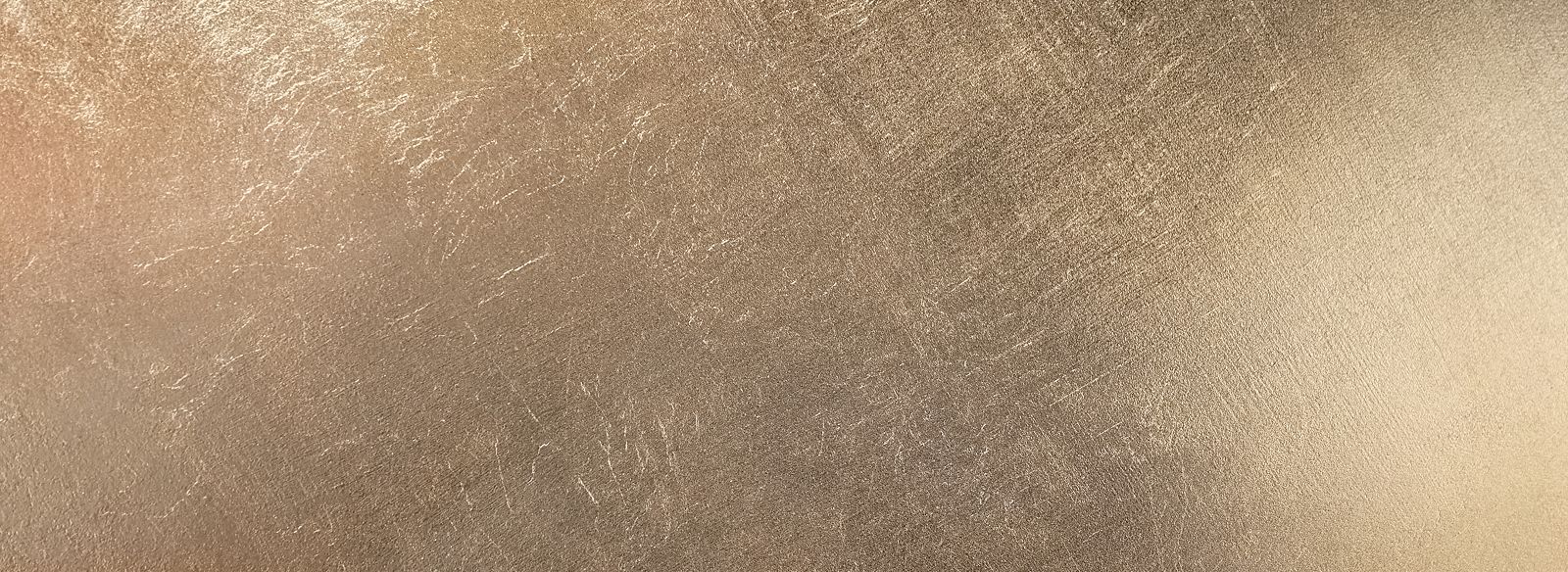 Textured metallic surface in warm gold tones.