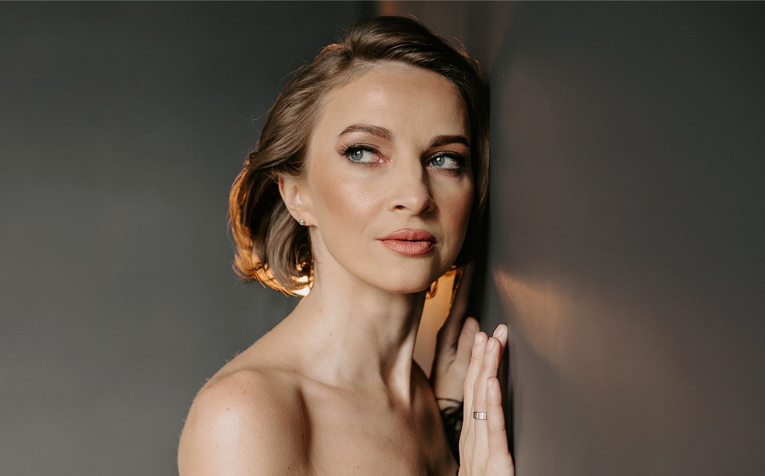 Hyperbaric Oxygen Therapy model gently touching her face, looking thoughtful.