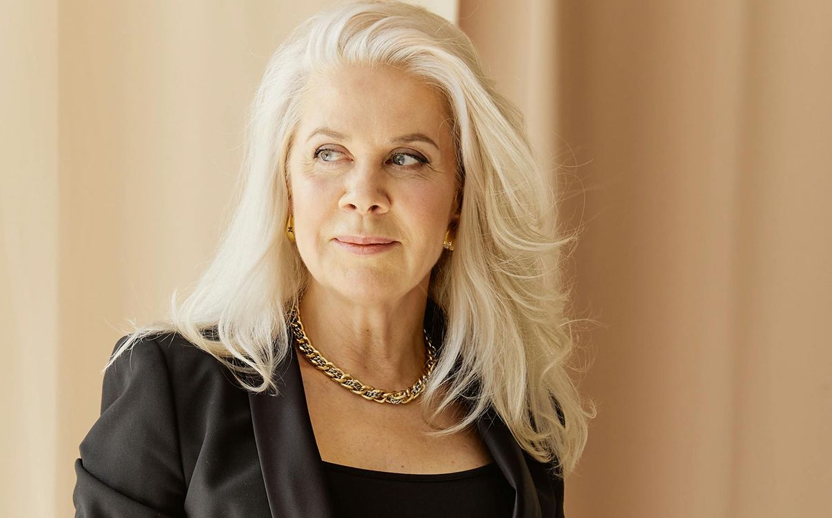 HBOT model with long blonde hair and elegant attire.