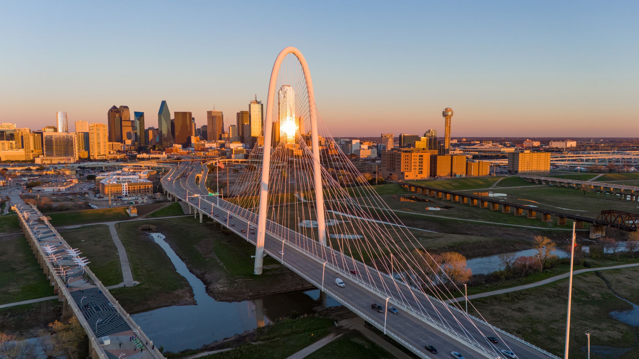 Dallas skyline with bridge at sunset.